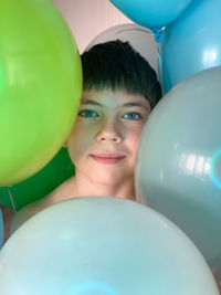 Full frame shot of balloons and face of young boy