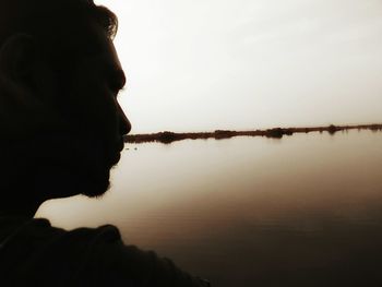 Reflection of man in water against clear sky