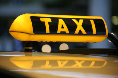 Close-up of yellow sign on car