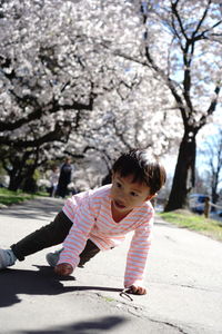 Side view of young woman standing on tree