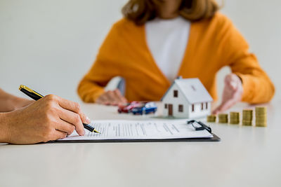 Midsection of woman holding umbrella on table