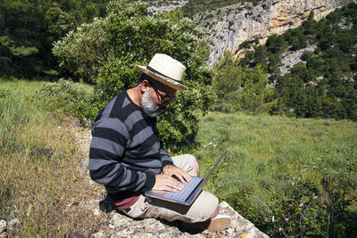 Midsection of man sitting in park