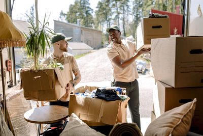 Multiracial movers unloading boxes from delivery truck