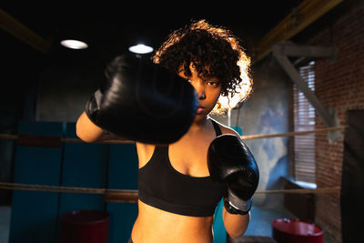 Side view of young woman exercising in gym