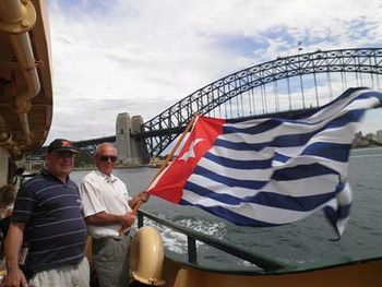 Men standing by flags against sky