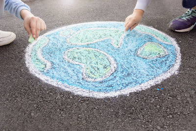 Children draw the world, the planet earth with chalk on the pavement.stop war.