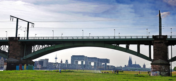 Arch bridge in city against sky