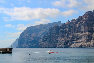 Scenic view of sea and mountains against sky