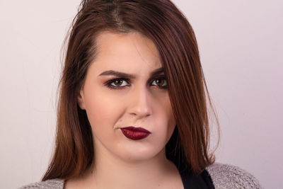 Portrait of woman making face against wall