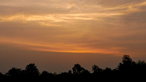 Low angle view of silhouette trees against romantic sky