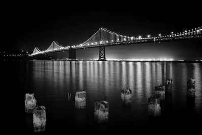 View of suspension bridge over river at night