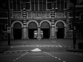 Empty road amidst buildings in city