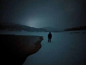 Rear view of silhouette man standing on beach