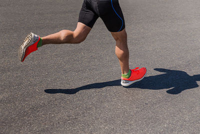 Legs male runner athlete run on asphalt road