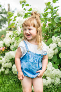 Girl smiling while standing against plants