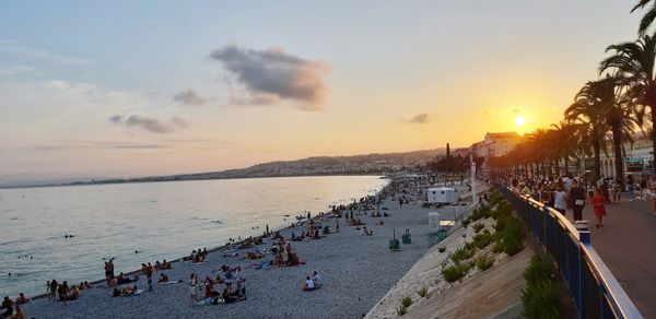 High angle view of people by sea against sky during sunset