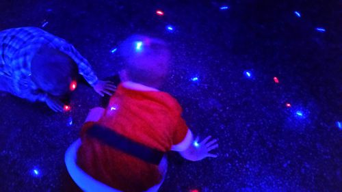 Close-up of illuminated blue against sky at night