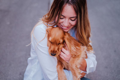 Smiling woman with dog on land in city