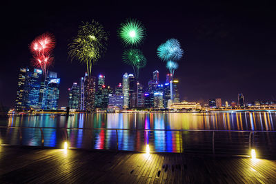 Firework display over illuminated buildings in city at night