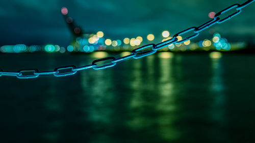 Close-up of chain against sea at night