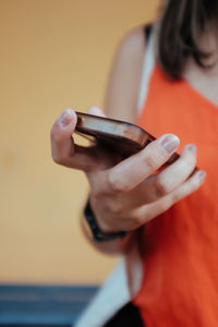 Midsection of woman holding smart phone