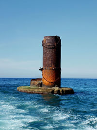 Scenic view of sea ruin against clear blue sky