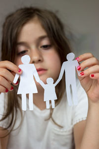 Sad girl holding paper chain