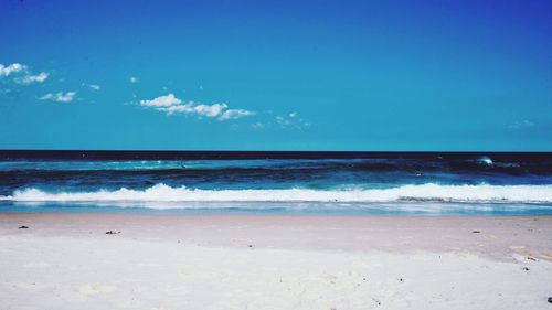 Scenic view of beach against blue sky