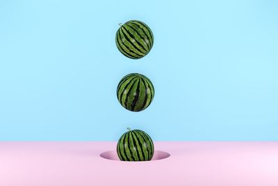 Digital composite image of watermelon over colored background