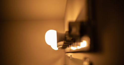 Close-up of illuminated light bulb at home