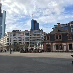 Buildings in city against cloudy sky