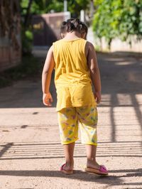 Rear view of woman standing on footpath