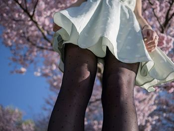 Rear view of woman standing on tree trunk