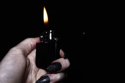 Close-up of hand holding candle