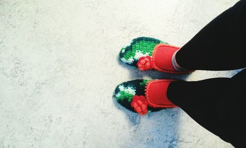 Low section of man standing by multi colored shoes