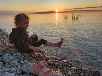 Full length of girl on beach against sky during sunset