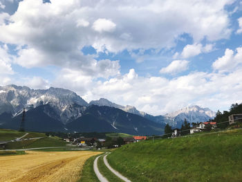 Road amidst field against sky