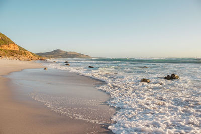 Scenic view of beach against clear sky