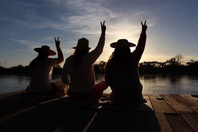 Three women on jetty at sunset