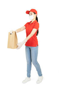 Full length portrait of woman standing against white background