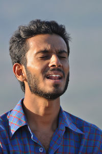 Close-up portrait of man against gray background