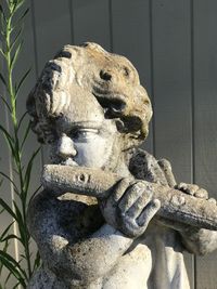 Close-up of old statue against wall