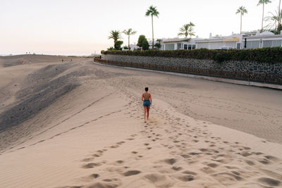 Rear view of woman walking on beach
