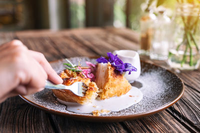 Midsection of person preparing food in plate on table