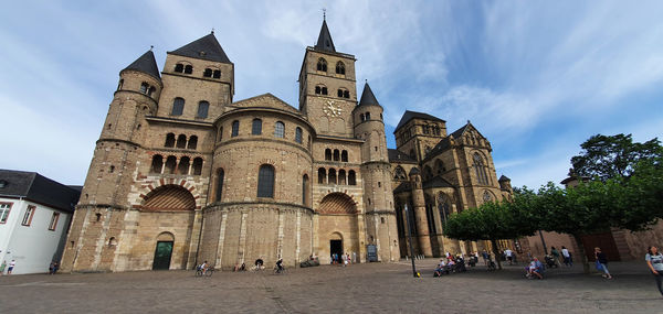 Group of people in front of historic building against sky