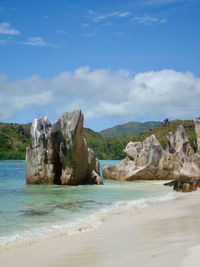 Rock formation on beach against sky