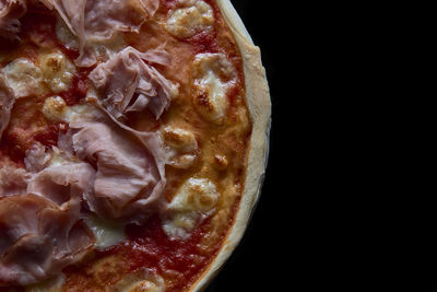 High angle view of pizza in glass over black background