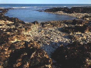 High angle view of rocks by sea against sky