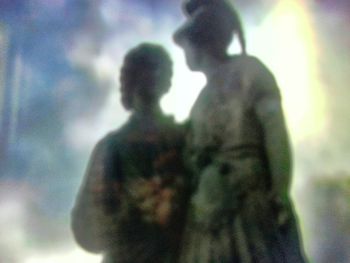 Low angle view of two silhouette people against sky