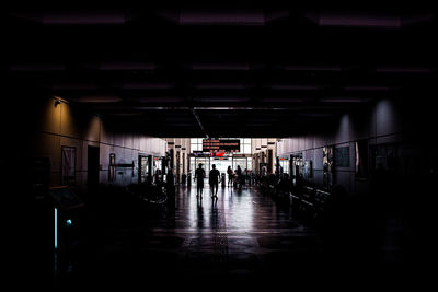 People walking in illuminated corridor of building